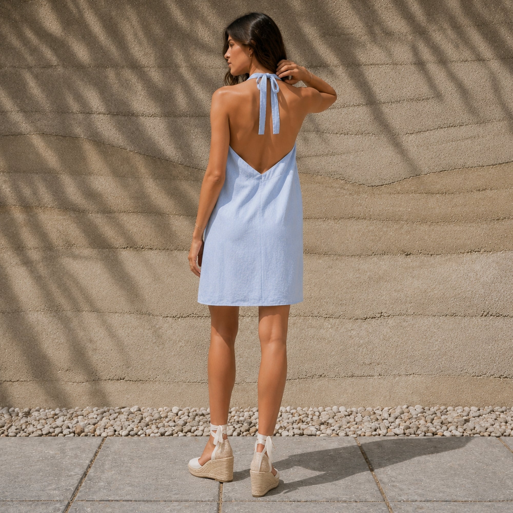 Vestido halter de lino en azul claro, vista lifestyle 2, mostrando el escote y la silueta del vestido