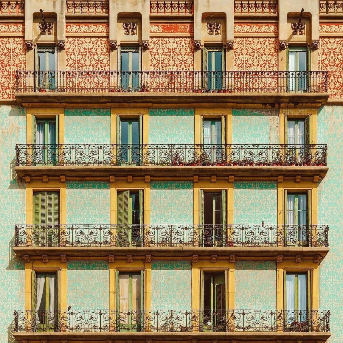 Facciata colorata di un edificio a Barcellona con balconi, simbolo del modello di preordine di Pamuuc.